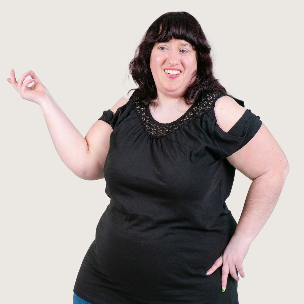 Chrissie - A young white woman wearing a black dress. She has long dark hair and is posing for the camera.