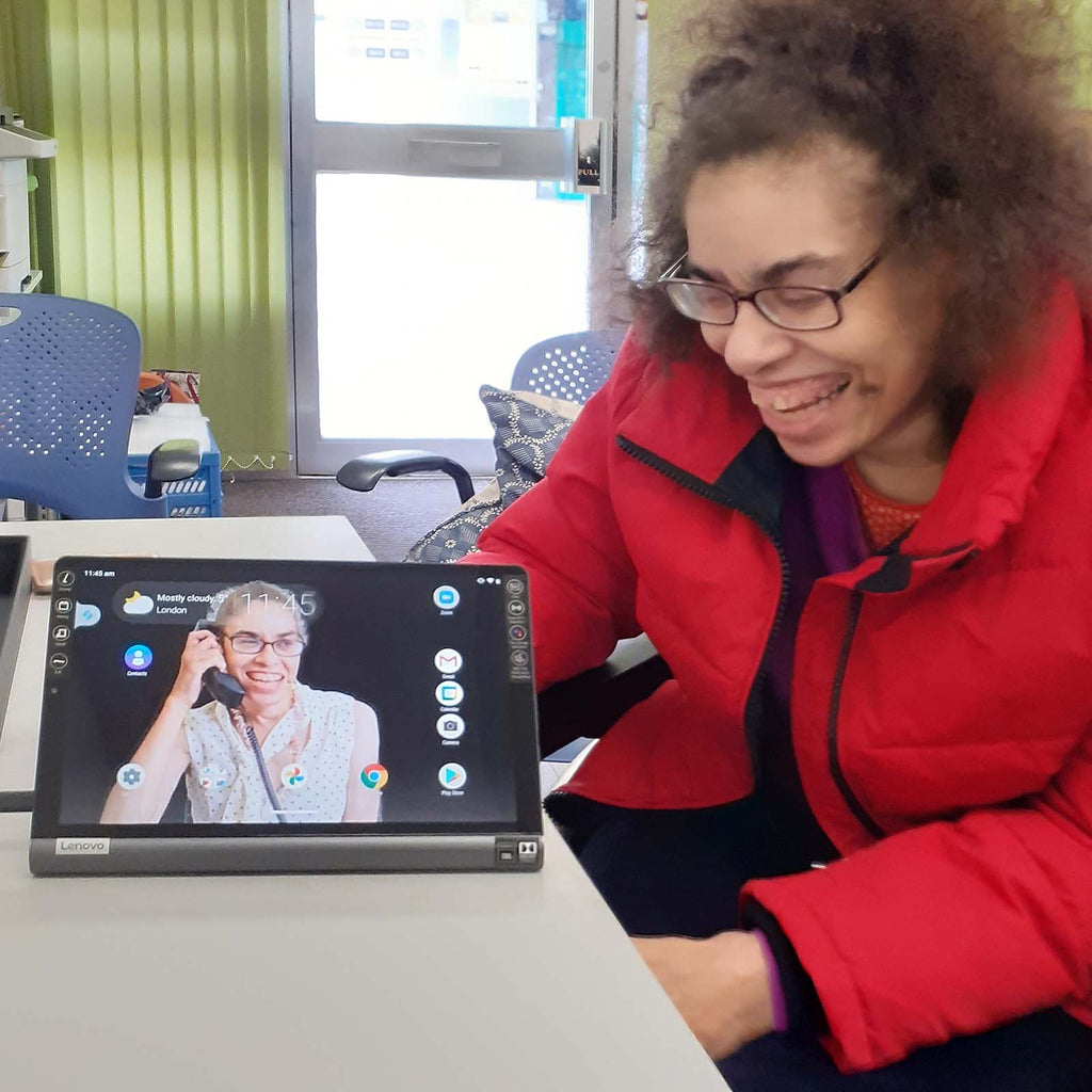 A photo of Michaela who is home working as an Expert Adviser. She is showing us the tablet she uses for zoom calls.