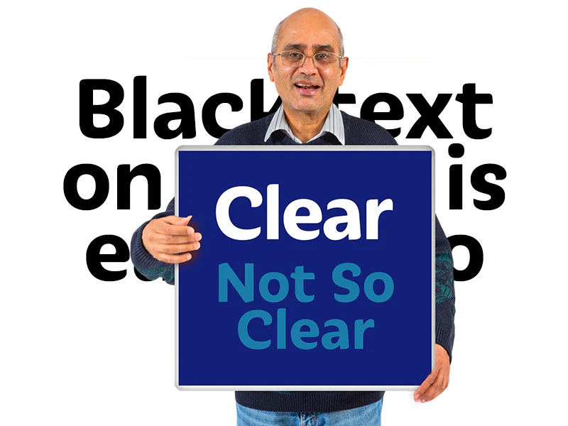 A man in a dark blue jumper holds a sign demonstrating differing contrast between clear and unclear text.