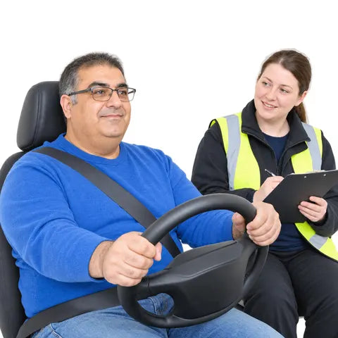 A man with glasses at the wheel, with a driving examiner in a hi-vis vest beside him.